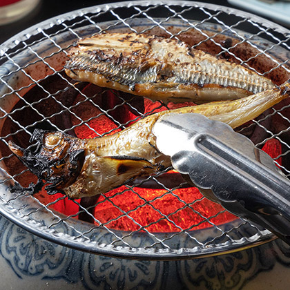 grilling the fish over charcoal